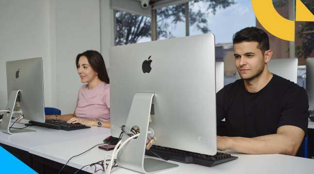 Dos jóvenes sentados frente a un computador estudiando en CET Colsubsidio