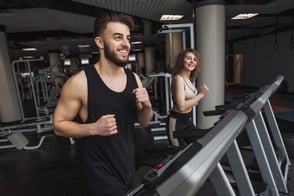 Un hombre y una mujer corriendo en cinta de correr