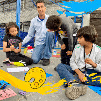 Un grupo de niños en clases junto a su profesor.