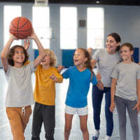 Grupo de niños practicando baloncesto en las instalaciones de Colsubsidio.