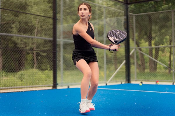 Mujer en una cancha jugando Pádel