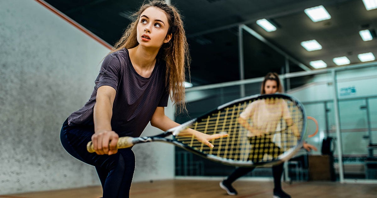  Entrena squash, tenis de campo y taekwondo en las escuelas deportivas de Colsubsidio. Aprende o mejora tu técnica con entrenadores expertos e instalaciones modernas.   Dos mujeres jugando squash en el Club Bellavista de Colsubsidio. 